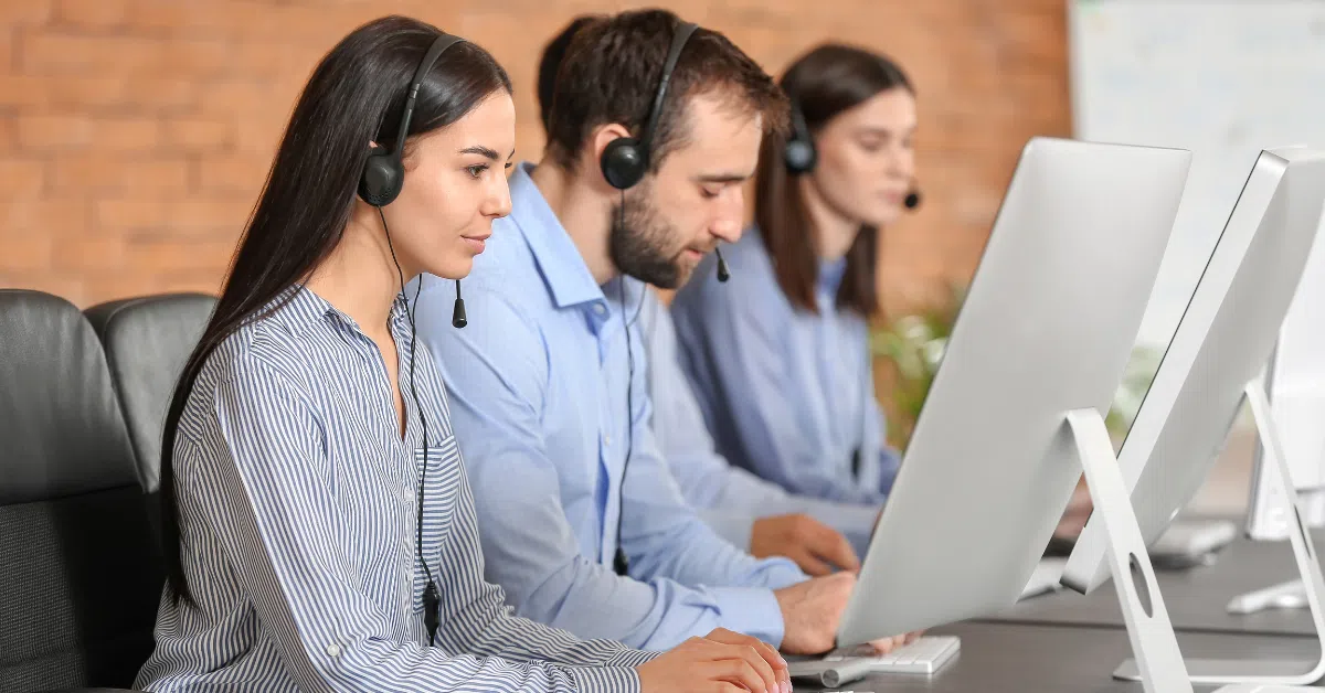 Focused Colombian customer support specialists working remotely on desktop computers.